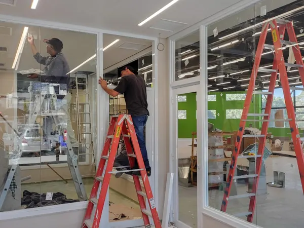 Instaladores da ARB Vidros instalando esquadria em obra comercial