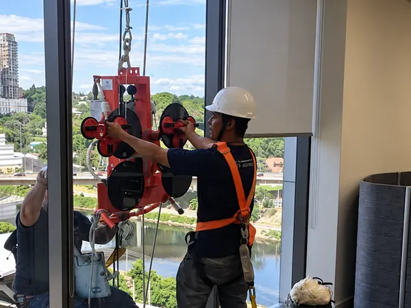 Instaladores da ARB Vidros movendo vidro com equipamento de seguranca